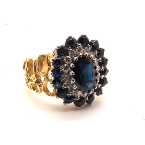 138 - A Large Sapphire and Diamond Cluster Dress Ring, oval claw set to the centre, within two row border ... 