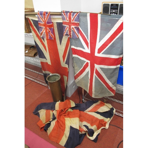 319 - A Selection of Union Flags, with varying wear/tear and a large trench art artillery cartridge.