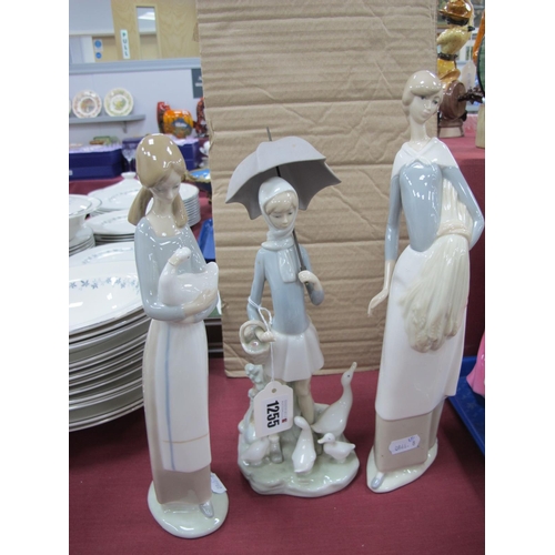 1255 - Lladro Figure of Girl Holding Umbrella with ducks at her feet, Nao figure of girl holding sheaf of c... 