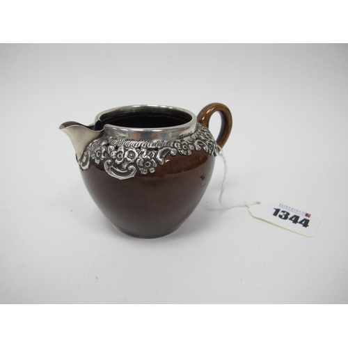 1344 - Treacle Glaze Pottery Jug, with silver rim and embossed shoulders, Birmingham 1906, 6.5cm high.