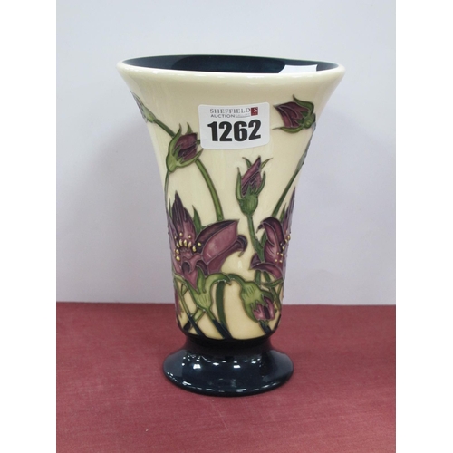 1262 - Moorcroft Pottery Vase, with fanned rim decorated with mauve flowers on blue base, 15.5cm high.