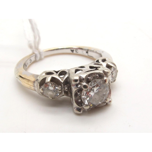 106 - A Three Stone Diamond Ring, high set to the centre with  brilliant cut diamond, between two smaller ... 