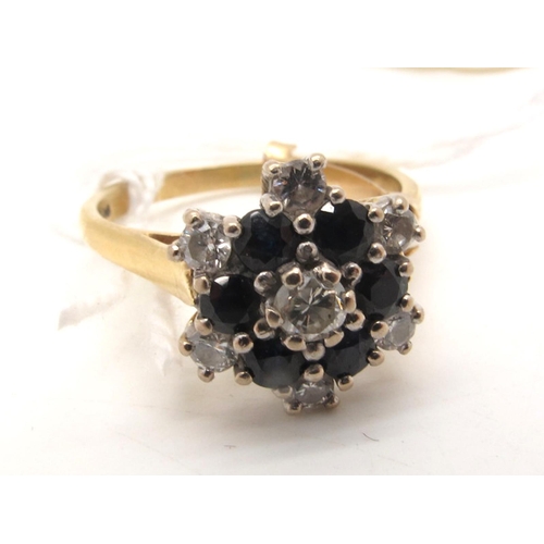 115 - An 18ct Gold Sapphire and Diamond Cluster Ring, high claw set throughout, between plain shoulders (f... 