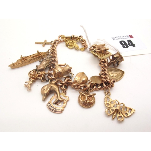 94 - A 9ct Gold Curb Link Charm Bracelet, to swivel style clasp, suspending numerous novelty charm pendan... 