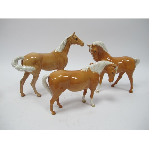 1053 - Beswick Pottery Palomino Type Horses, the largest 21.5cm high, with ear repair. (3)