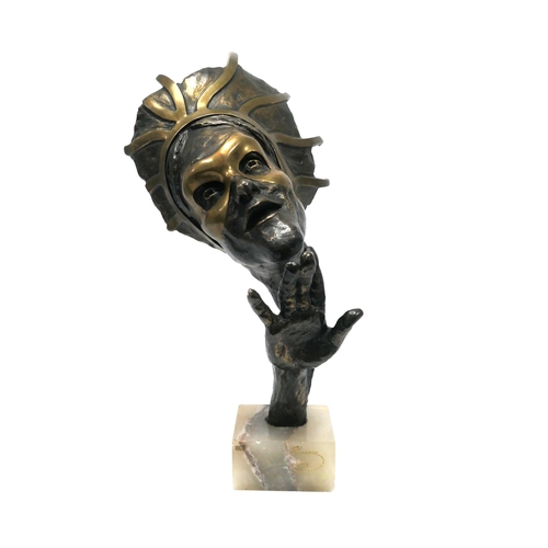 1145 - A Mid XX Century Bust, with raised hand, wearing a mask and head piece, the marble rectangular base ... 