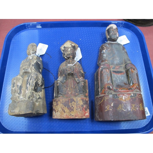 1245 - Three Chinese Carved Wooden Deities, each with painted details, 21 - 28cm high. (3)