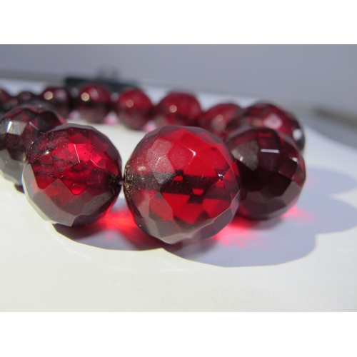 77 - A Long Single Strand Faceted Cherry Amber Coloured Bead Necklace.