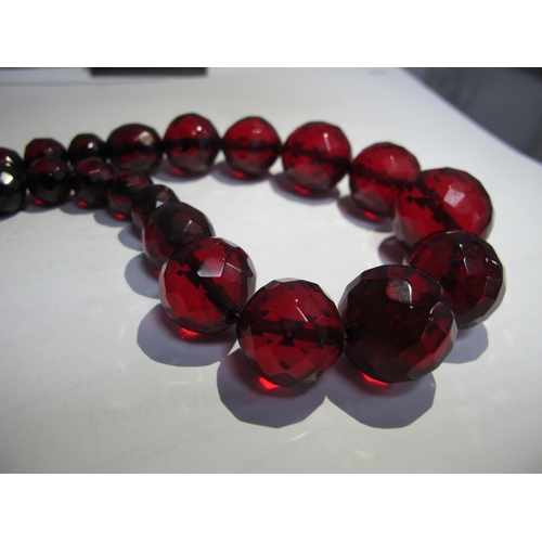 77 - A Long Single Strand Faceted Cherry Amber Coloured Bead Necklace.
