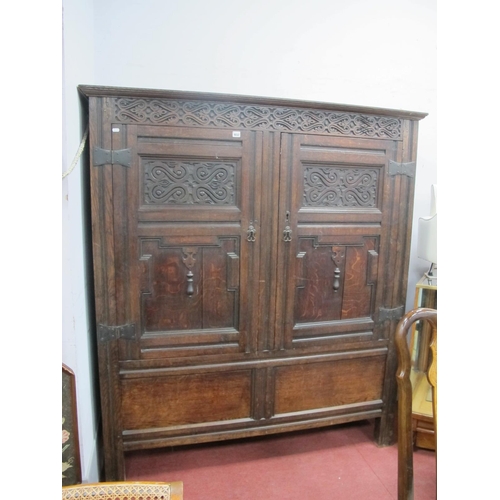 1652 - A XVII Century Joined Oak Livery Cupboard, with carved frieze, twin cupboard doors and panelled base... 