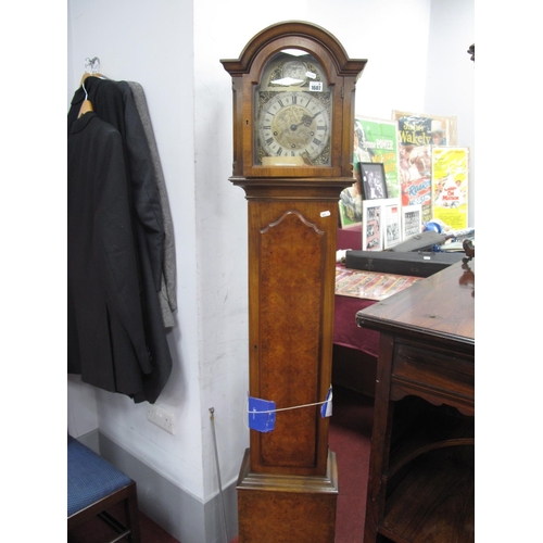 1607 - A XX Century Walnut Grandmother Clock, with a arched hood, shaped trunk door, plinth base, with a si... 