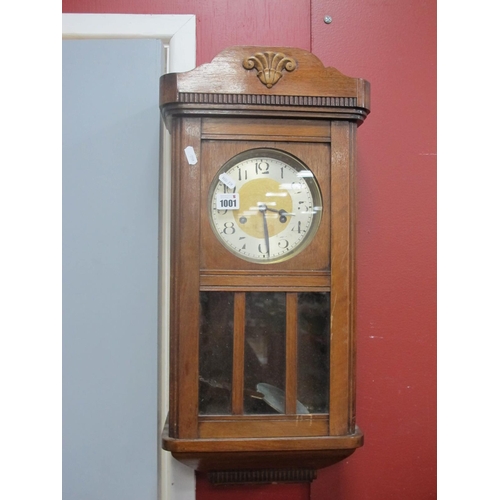 1001 - A 1940's Mahogany Wall Clock, with a silver chapter ring, glazed door, 65cm wide.