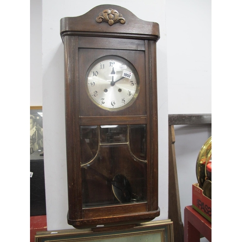 1052 - A XX Century Oak Wall Clock, with a silvered dial, glazed door.