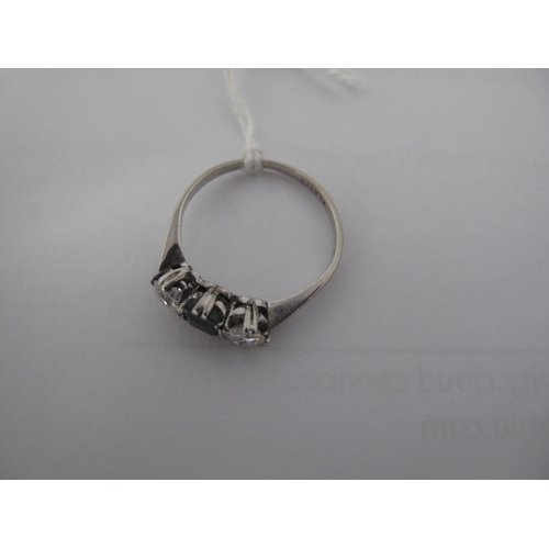 351 - A Three Stone Dress Ring, alternately claw set between tapered shoulders, stamped 