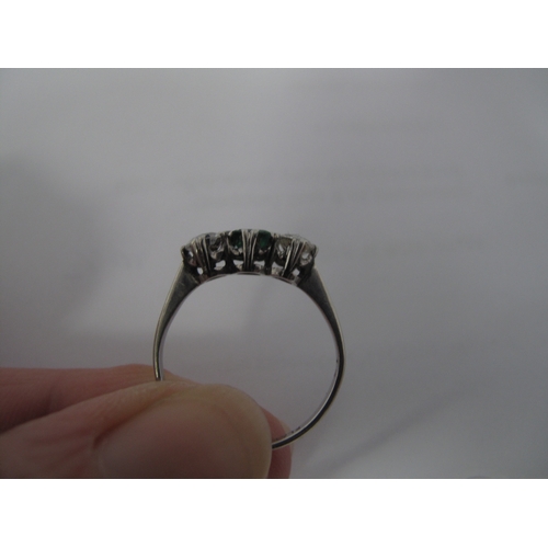 351 - A Three Stone Dress Ring, alternately claw set between tapered shoulders, stamped 