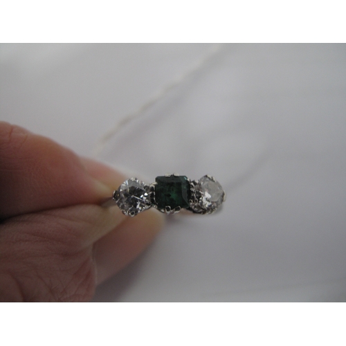 351 - A Three Stone Dress Ring, alternately claw set between tapered shoulders, stamped 