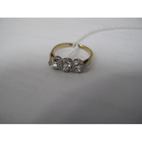 381 - A Three Stone Diamond Ring, claw set throughout, between plain shoulders, stamped 