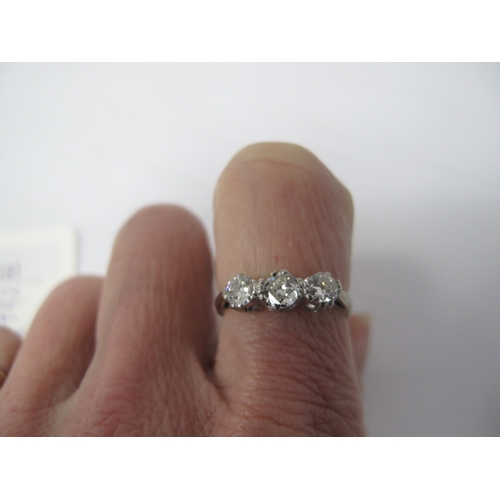 381 - A Three Stone Diamond Ring, claw set throughout, between plain shoulders, stamped 