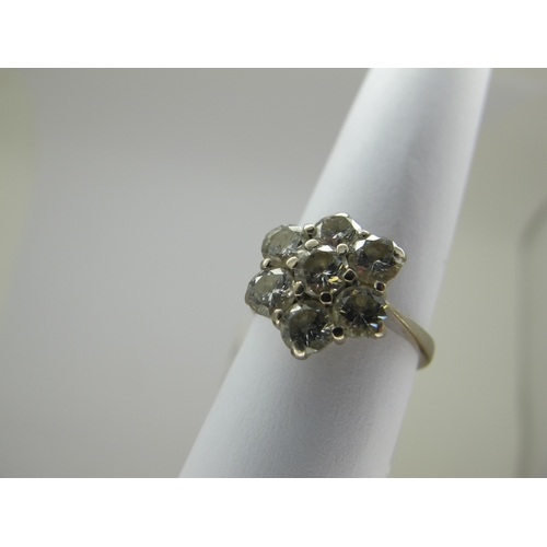 214 - An 18ct White Gold Seven Stone Diamond Flowerhead Cluster Ring, claw set throughout with brilliant c... 