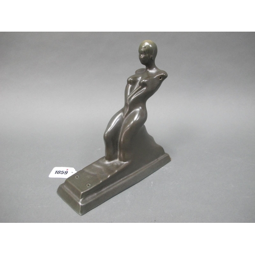 1059 - An Art Deco Pottery Figure of a Reclining Female, in a bronze effect finish, on stepped plinth (abse... 