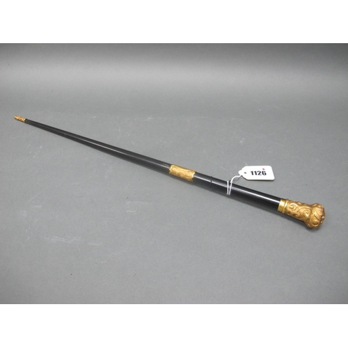 1126 - A Late XIX Century Baton, the tapered stick with yellow metal mounts and pommel cast with scrolling ... 