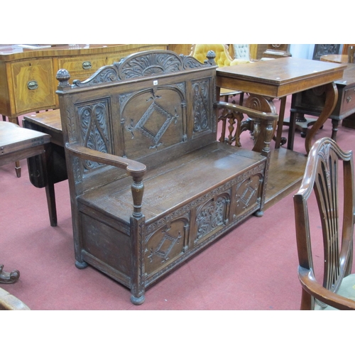 1484 - A XX Century Carved Oak Box Settle, with arched top rail, turned finials, centre back panel with loz... 