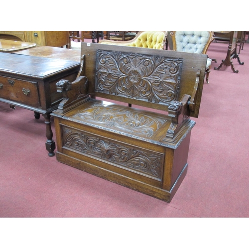 1487 - An Early XX Century Carved Oak Monks Bench, the folding back with carved border, hinged seat, the ba... 