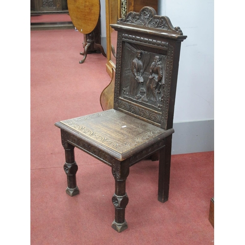 1489 - A XIX Century Carved Oak Hall Chair, with carved top rail and back panel carved with two figures and... 