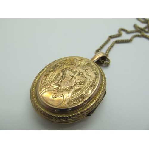 132 - A Decorative Victorian Oval Locket Pendant, allover decorated, suspended on a long fancy link chain.