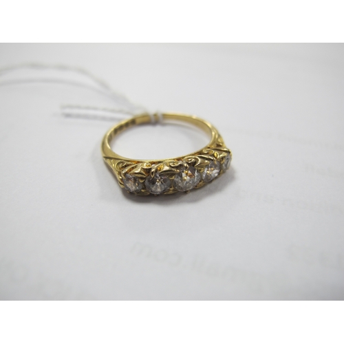 221 - An Edwardian 18ct Gold Five Stone Diamond Ring, the graduated old cut stones within scroll carved se... 