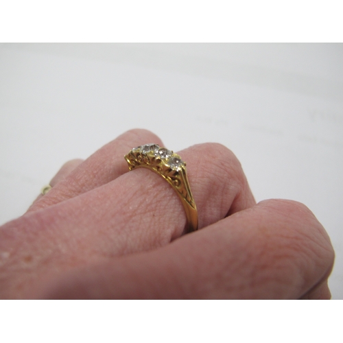 221 - An Edwardian 18ct Gold Five Stone Diamond Ring, the graduated old cut stones within scroll carved se... 