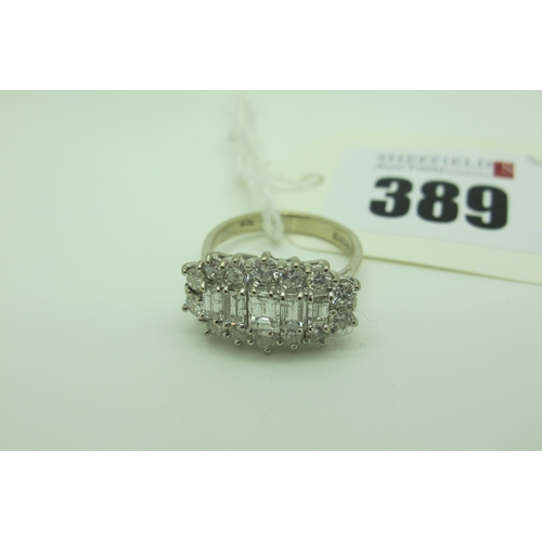 389 - An 18ct White Gold Large Cluster Dress Ring, claw set throughout with graduated baguette cut stones ... 