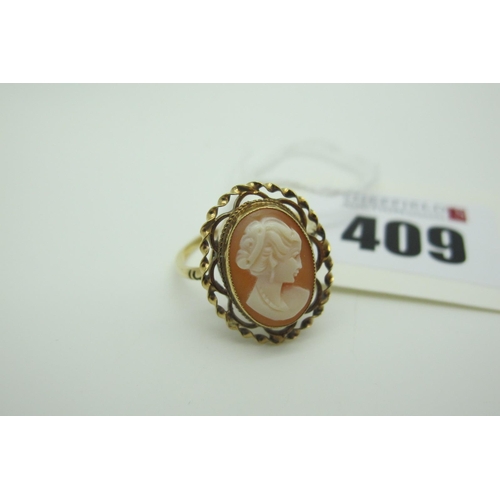 409 - An Oval Cameo Dress Ring, oval collet set within openwork setting (finger size R) (indistinctly stam... 