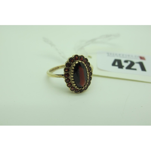 421 - A 9ct Gold Garnet Oval Cluster Ring, oval claw set to the centre (finger size M).