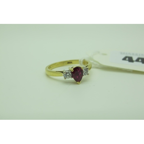 446 - An 18ct Gold Three Stone Ring, with teardrop claw set centre within four claw set highlights, betwee... 