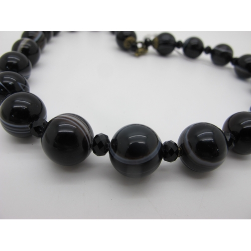 248 - A Banded Agate Bead Necklace, composed of uniform beads with faceted French Jet bead spacers.