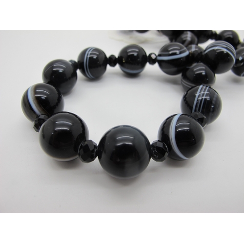 248 - A Banded Agate Bead Necklace, composed of uniform beads with faceted French Jet bead spacers.