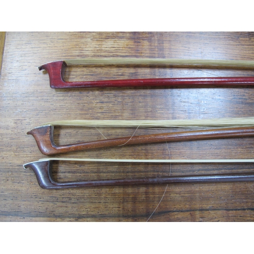 1357 - Three Violin Bows, each with nacre inset to frog, approximately 74cm long. (3).