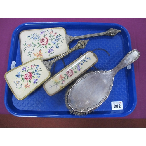 202 - A Hallmarked Silver Backed Brush, Birmingham 1917; together with a three piece needlepoint dressing ... 