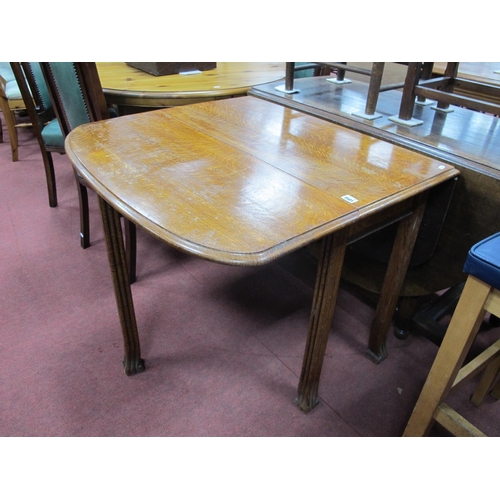 1501 - A XX Century Oak Drop Leaf Table, on shaped reeded legs.