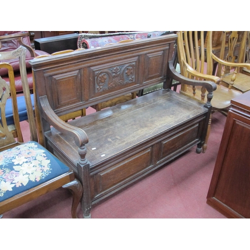 1583 - An Early XX Century Oak Hall Bench, with a panelled back, shaped arms, hinged seat, panelled base, 1... 