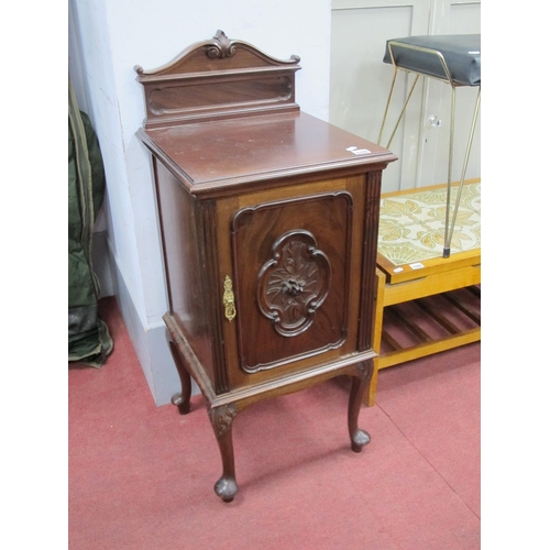 1590 - An Early XX Century Mahogany Bedside Cabinet, with a shaped low back, cupboard door with carved foli... 