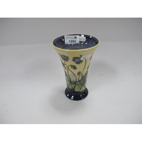 1252 - Moorcroft Pottery Vase, featuring violets on cream ground, of fanned form, 15.5cm high.