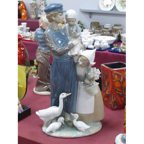 1284 - Lladro Figure Group, of a man holding a child, child by his side, and geese by his feet, 38cm high.