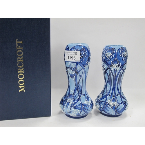 1195 - Moorcroft Pottery, a pair of bulbous vases in the Macintyre manner with stylized flowers in shades o... 