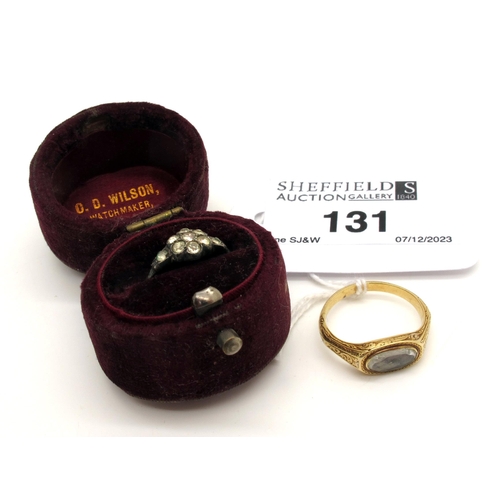 131 - A Dainty XIX Century Mourning Ring, the oval glazed panel encasing woven hair, within engraved setti... 
