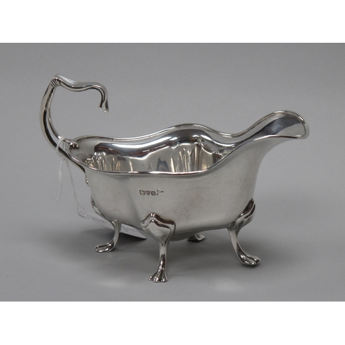 28 - A Hallmarked Silver Sauce Boat, Walker & Hall, Chester 1907, of Art Nouveau shaped design, with flyi... 