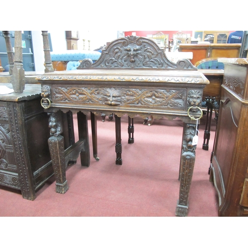 1573 - A XIX Century Carved Oak Side Table, with shaped back carved with a head, single drawer flanked by c... 