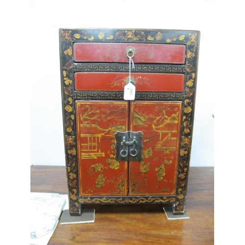 1582 - A Chinese Black Cabinet, with two red lacquer drawers over twin cupboard doors decorated with figure... 