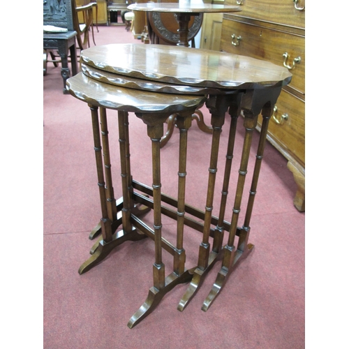 1585 - A XX Century Mahogany Nest of Tables, with scalloped edges, on turned and block supports.